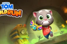 Cartoon cat in a red shirt runs through a glowing tunnel, chasing a colorful butterfly-like gem; game logo 'Talking Tom Gold Run' in the corner.
