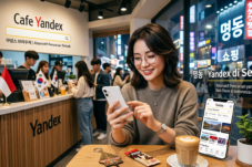 Young woman with glasses uses a smartphone at a Yandex cafe table, with staff and a counter in the background.