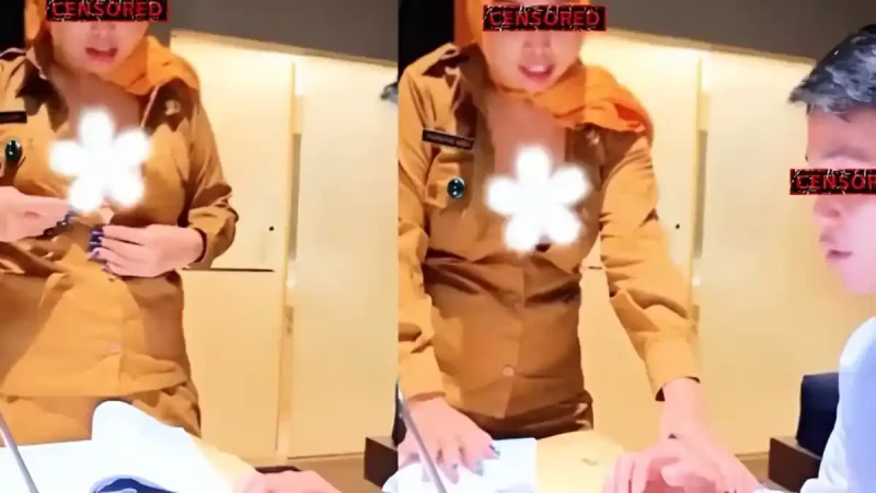 Two people in tan uniforms stand at a desk with papers; faces are censored and a white flower graphic covers a chest area on one person.