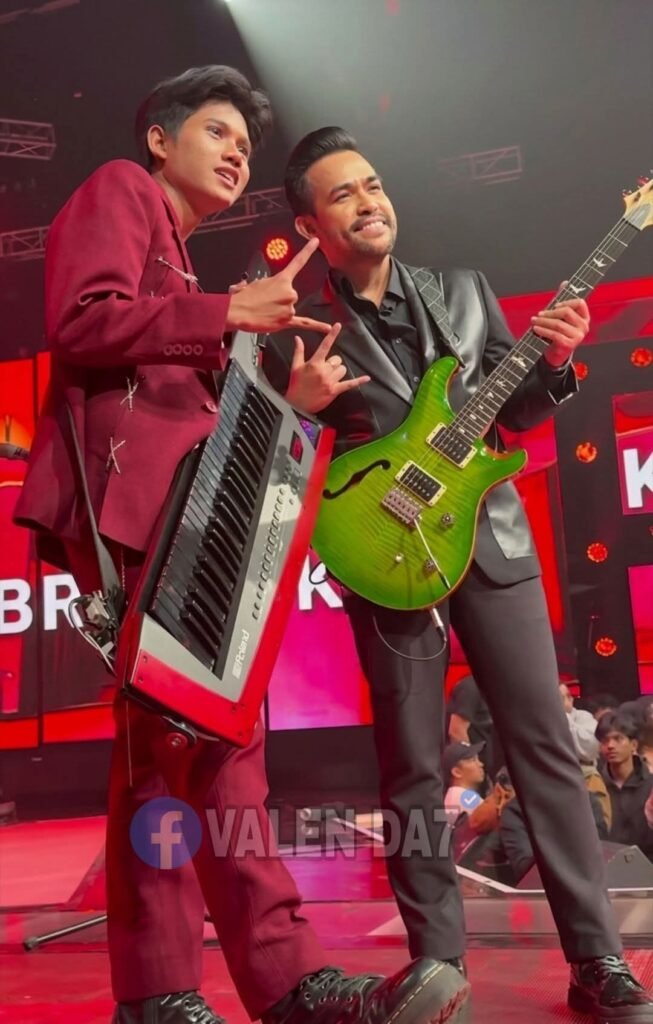 4065 | Map Bussid Terbaru Two male musicians on a red-lit stage pose with a keyboard (left) and a bright green electric guitar (right).